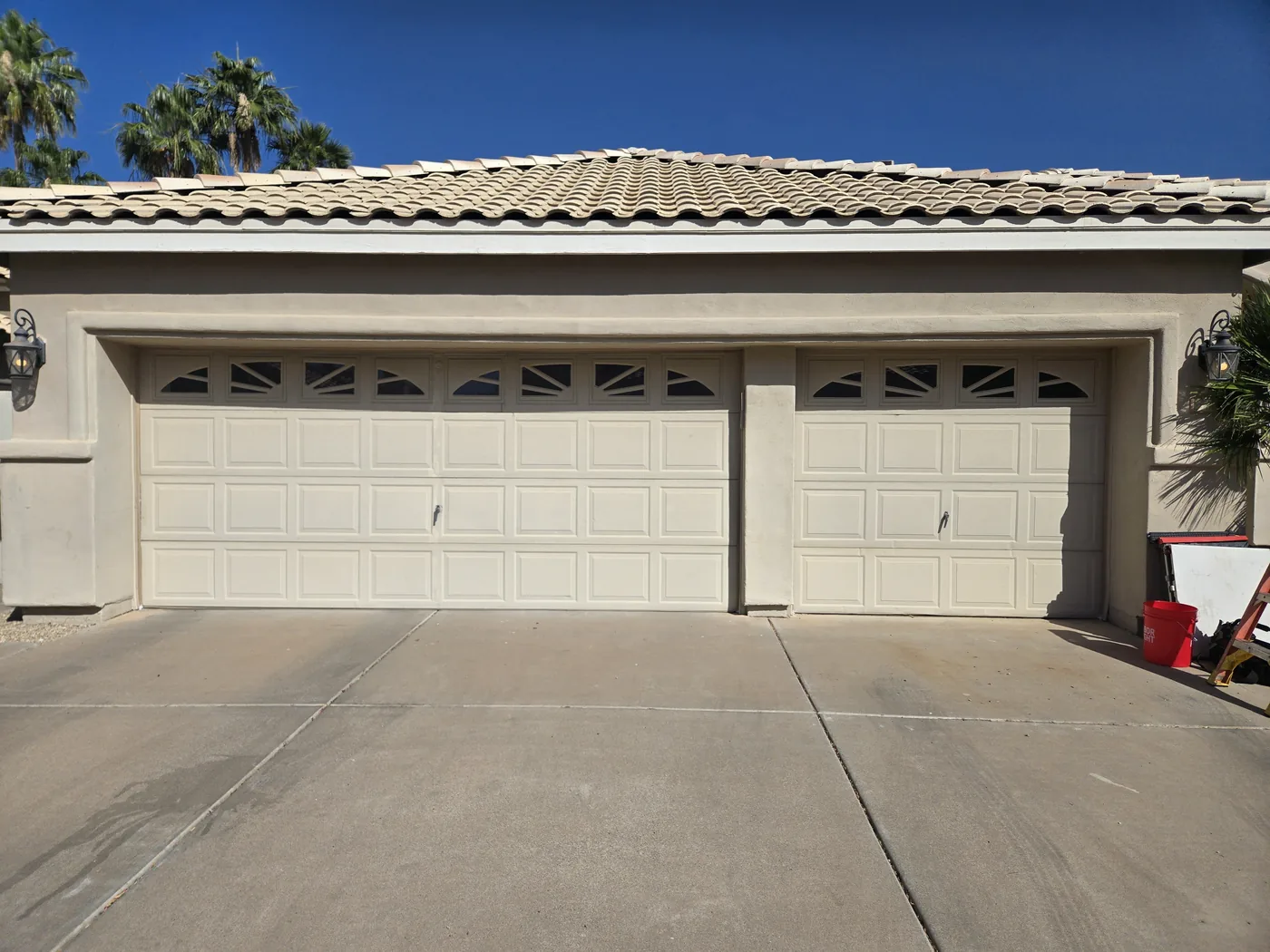 Old raised-panel garage doors with cracked panels before full replacement, Copper State Garage Pros, East Valley, AZ
