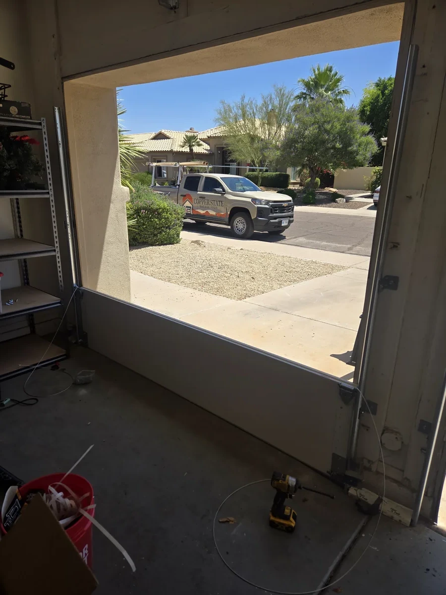 Garage door replacement in progress, Copper State Garage Pros truck visible in driveway during installation in the East Valley, AZ