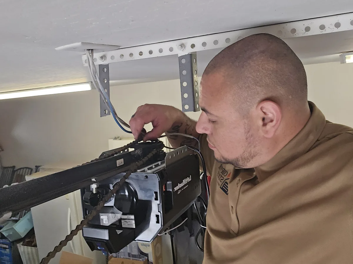 Nick Munoz, owner of Copper State Garage Pros, servicing a LiftMaster garage door opener in San Tan Valley, AZ