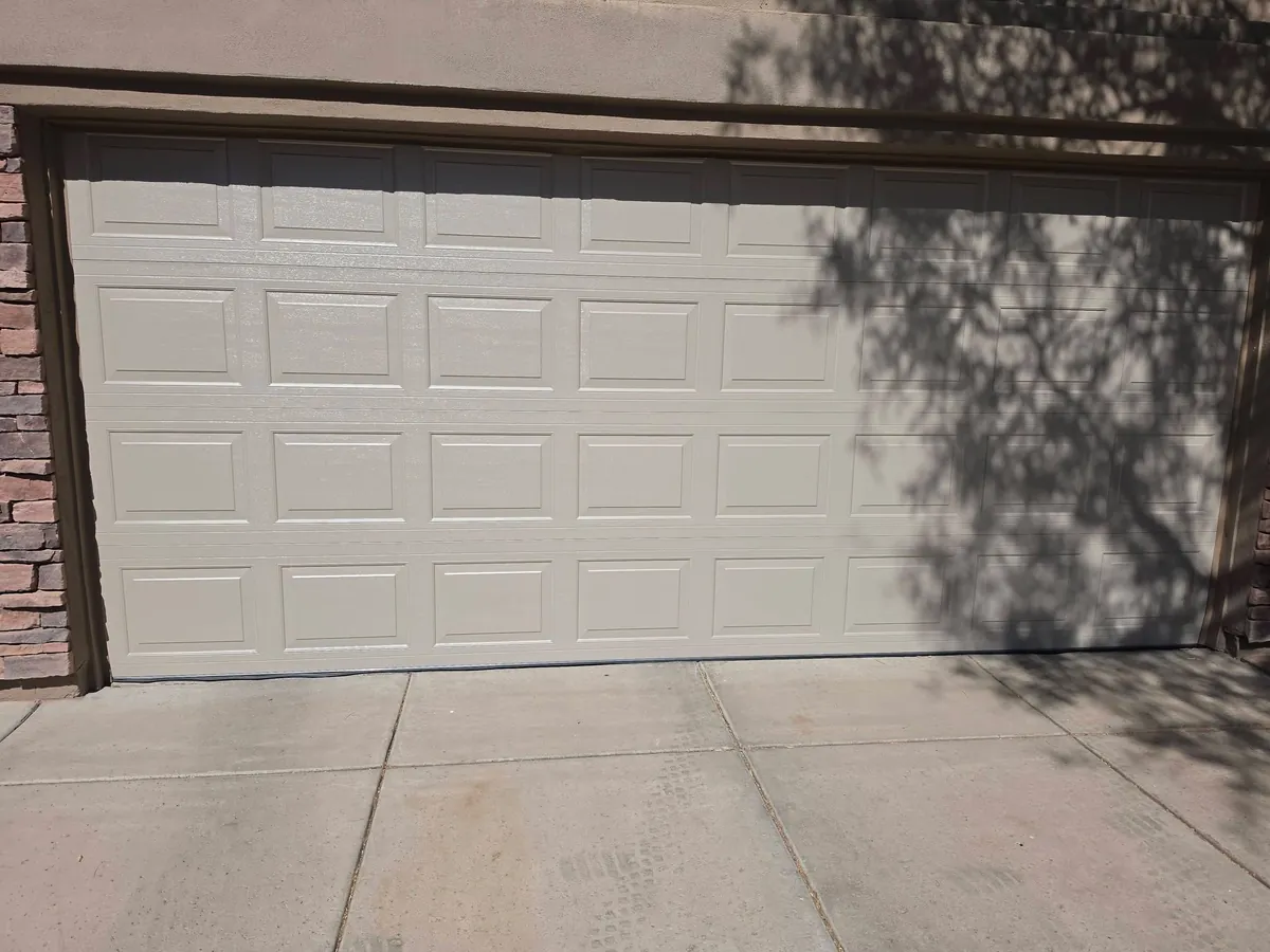 Exterior of a beige raised-panel residential garage door